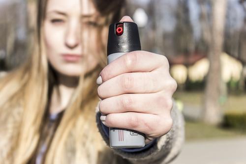 woman holding up pepper spray